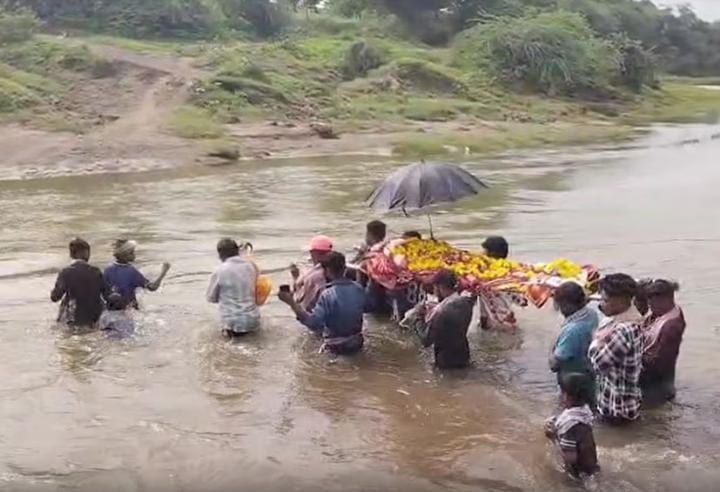 અંતિમ સંસ્કાર નનામી લઈને કિમ નદીના ધસમસતા પ્રવાહમાંથી પસાર થતા ગ્રામજનો